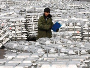 A worker counts alumnium ingots.