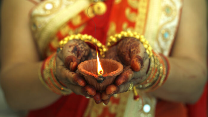 Indian woman holding Diwali oil lamp