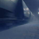 Passing cargo train in blurred motion at train station on a winter night